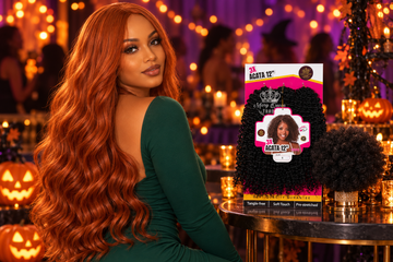 Black woman in a bold copper wig at a Halloween party, with a jumbo afro puff ponytail and a pack of 3X Acata crochet hair beside her